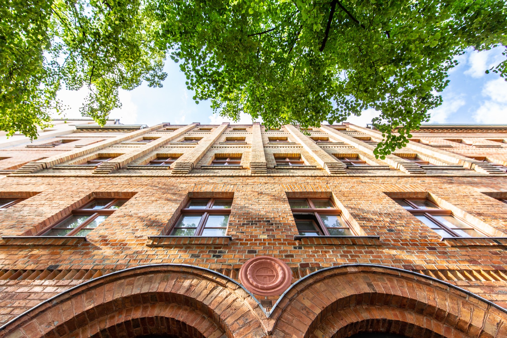 Kleine Bremer Höhe — brick façade rising into the trees, Torstraße 85–87